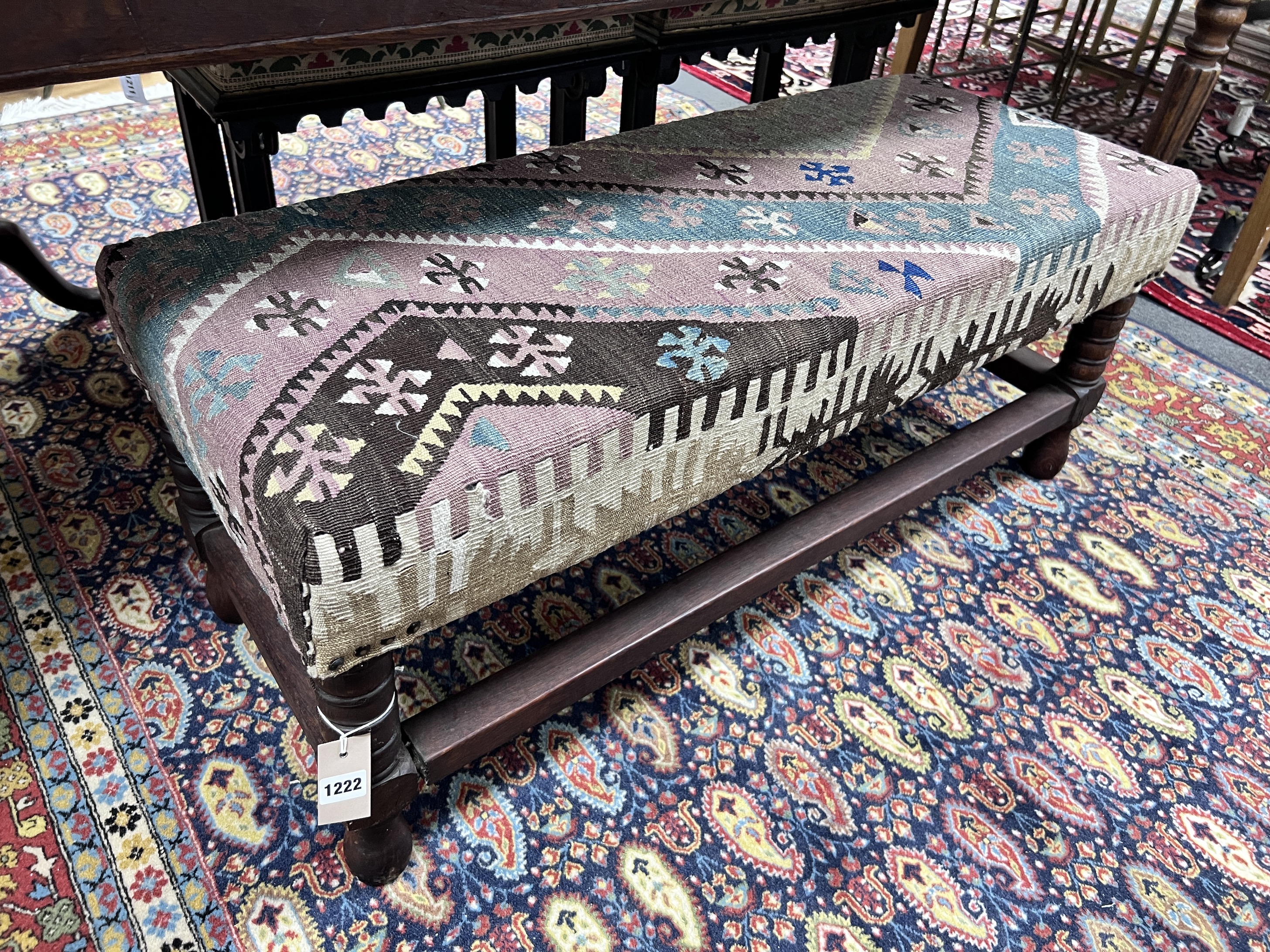 A 17th century style oak stool with contemporary Kilim upholstery, width 100cm